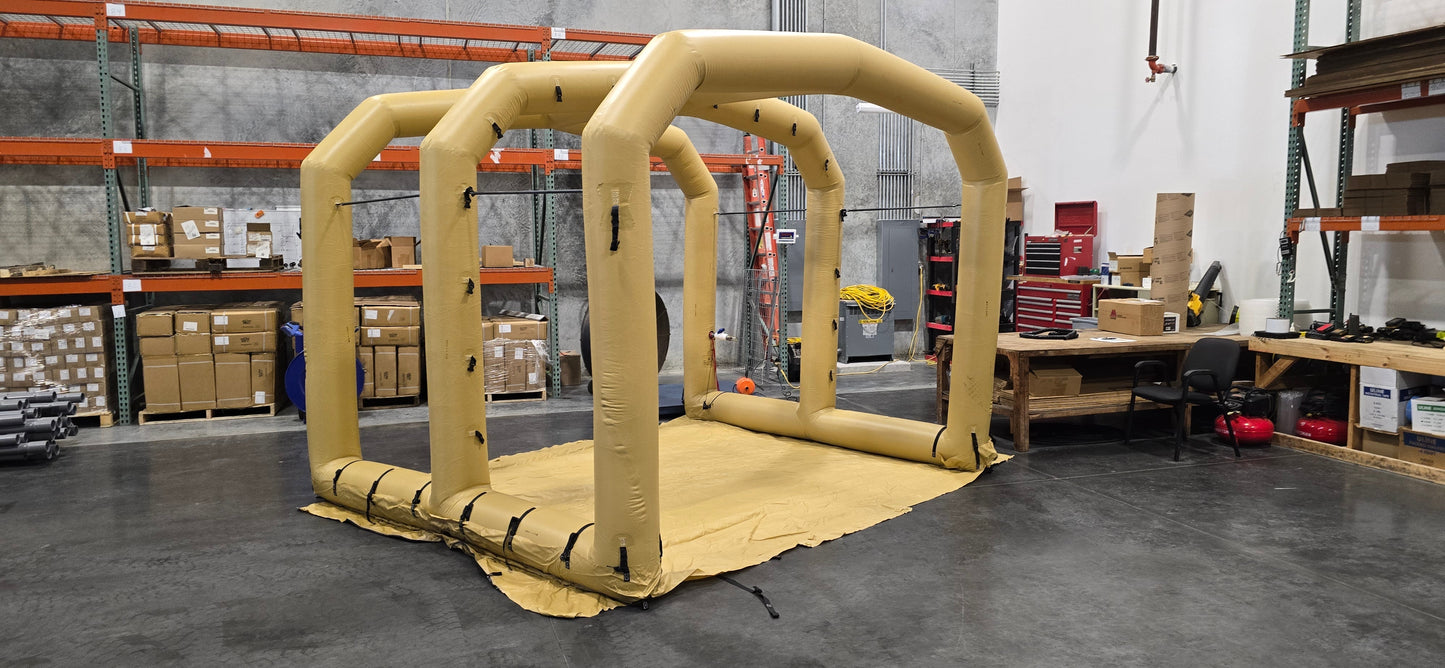Tan inflatable shelter frame set up inside warehouse with racks and pallets.