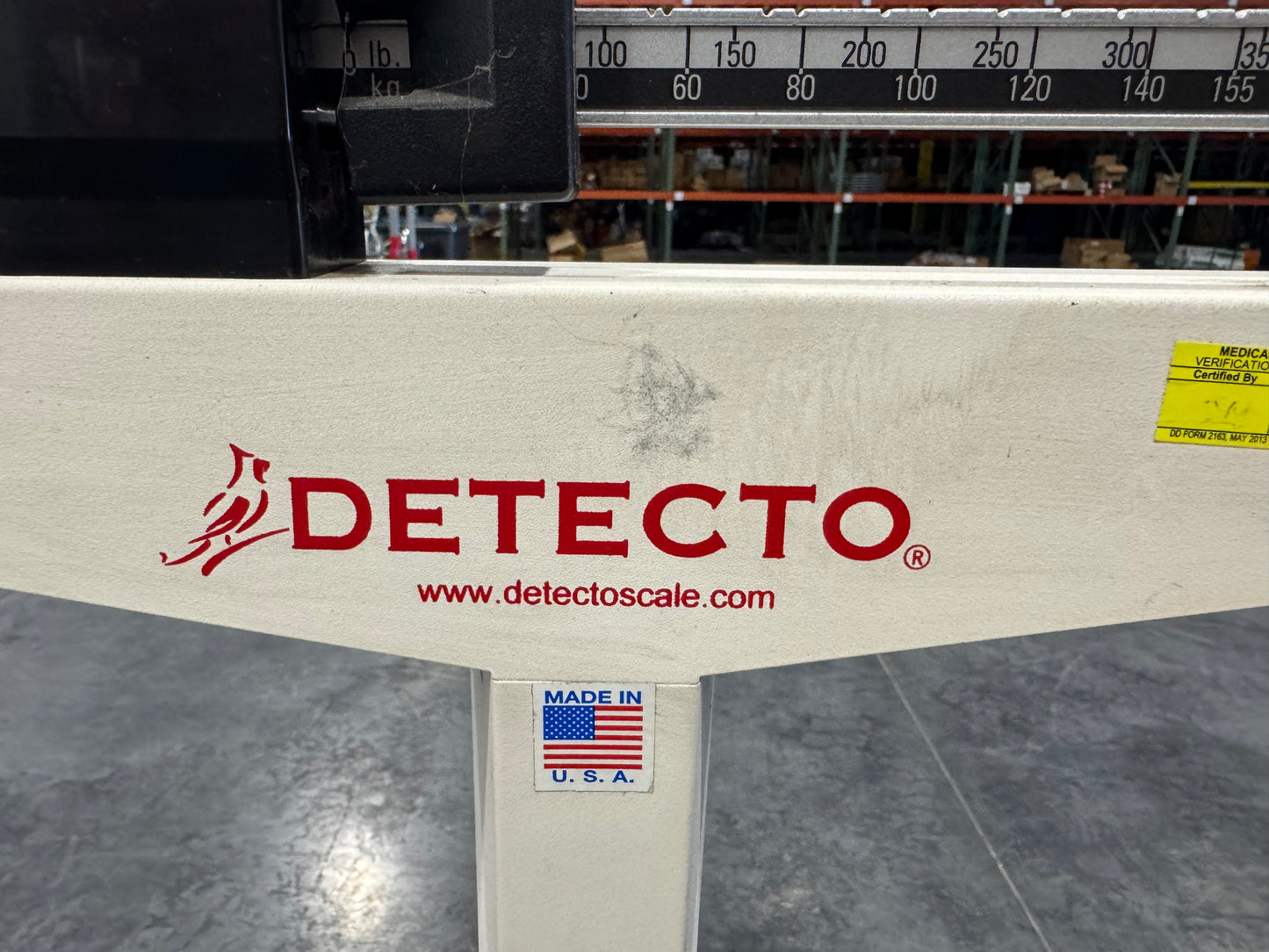 Detecto Eye-Level Physician Scale base showing red branding and measurement beam.